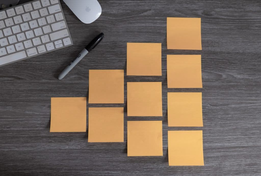 Auf dem Bild sind mehrere Post-it-Zettel neben einem Computer zu sehen