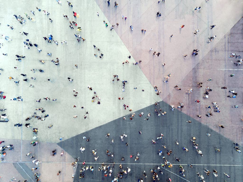 Das Bild zeigt eine Ansammlung an Menschen auf einem Platz aus der Vogelperspektive.
