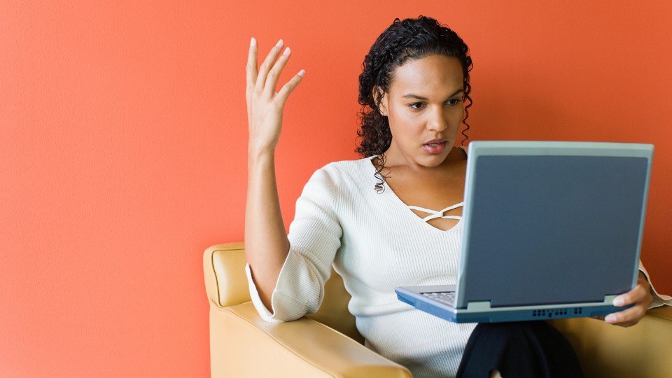 Eine Frau schaut frustriert in ihren Computer.
